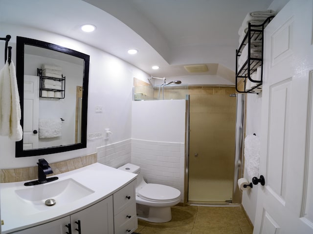 bathroom with walk in shower, tile patterned flooring, toilet, vanity, and tile walls