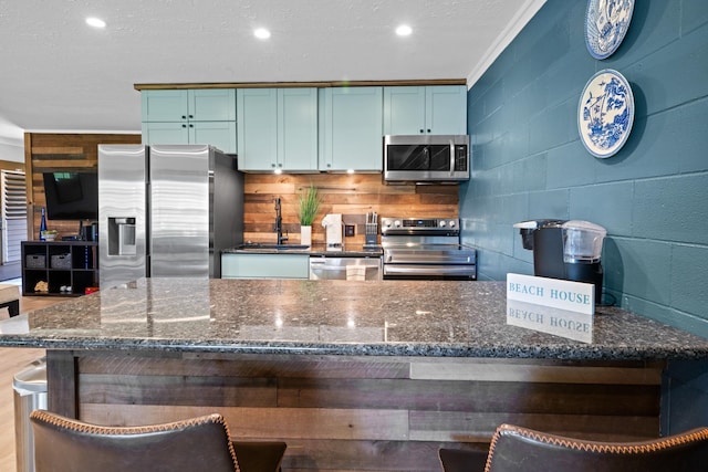 kitchen with dark stone counters, a textured ceiling, and stainless steel appliances