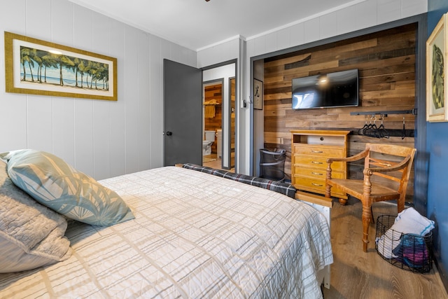 bedroom with a closet and wood walls