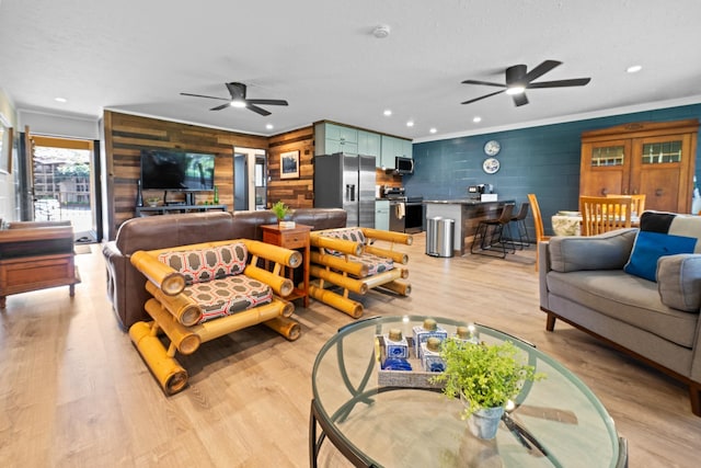 living room featuring wooden walls, light hardwood / wood-style floors, and ceiling fan