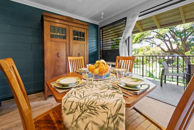 dining area featuring a textured ceiling and light hardwood / wood-style flooring