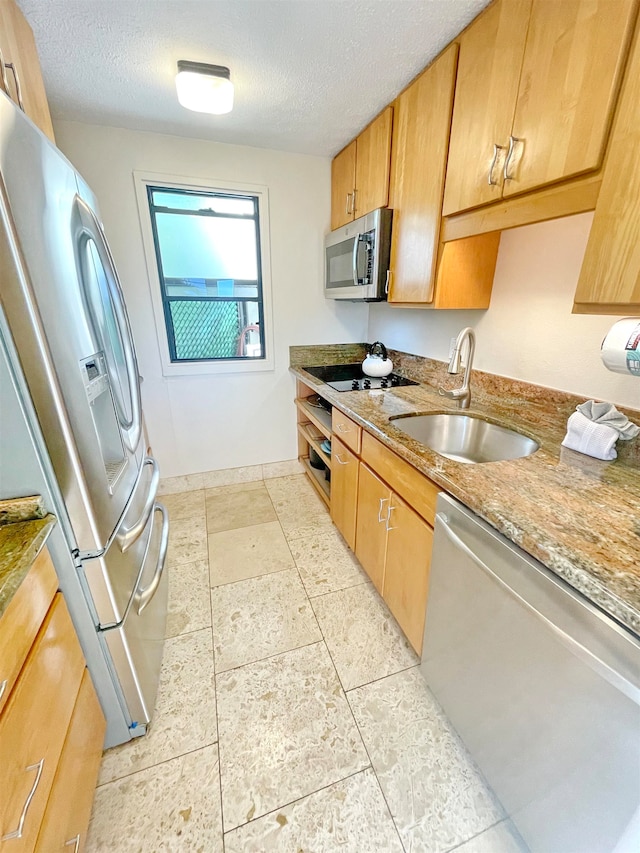 kitchen with light stone countertops, a textured ceiling, stainless steel appliances, and sink