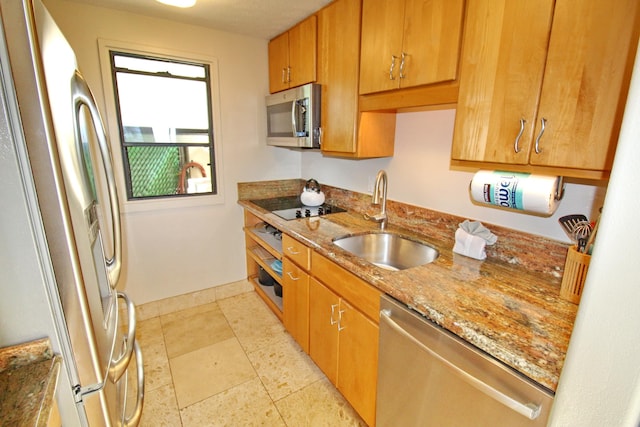 kitchen featuring light stone counters, sink, and stainless steel appliances