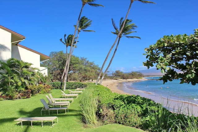 surrounding community featuring a view of the beach, a yard, and a water view