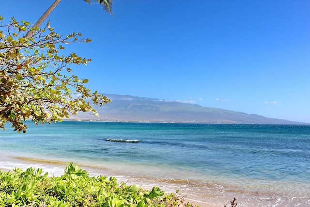 view of water feature with a mountain view and a view of the beach