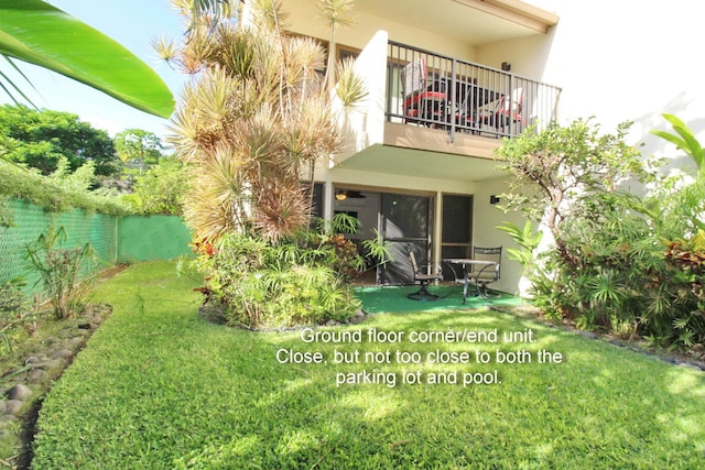 back of property featuring a balcony and a yard