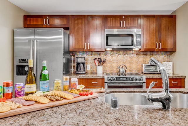 kitchen featuring backsplash, light stone counters, and high end appliances