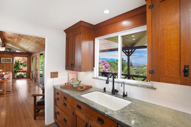 679 Kaapuni Pl, Kihei, HI 96753 - kitchen with decorative backsplash, plenty of natural light, brown cabinets, lofted ceiling, and recessed lighting