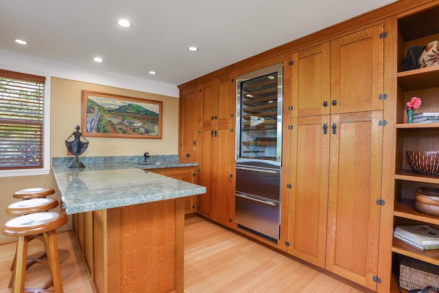 679 Kaapuni Pl, Kihei, HI 96753 - kitchen featuring a peninsula, brown cabinets, light wood-style flooring, wine cooler, and open shelves