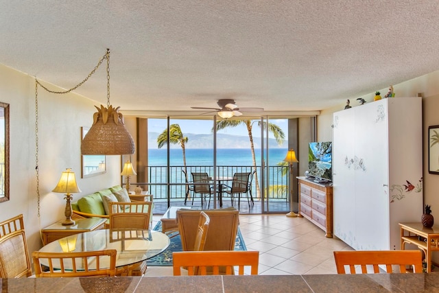 tiled dining space with floor to ceiling windows, ceiling fan, and plenty of natural light