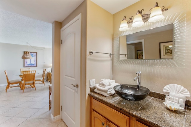 bathroom with tile patterned floors, vanity, and a textured ceiling