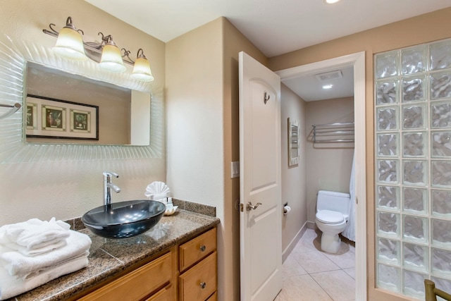 bathroom featuring tile patterned floors, vanity, and toilet