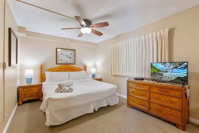 carpeted bedroom featuring ceiling fan and a textured ceiling