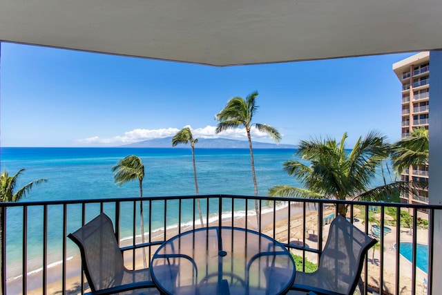 balcony featuring a view of the beach and a water view