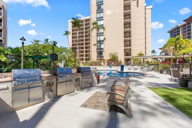 view of patio / terrace with area for grilling and a community pool