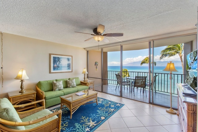 tiled living room featuring ceiling fan, floor to ceiling windows, and a textured ceiling