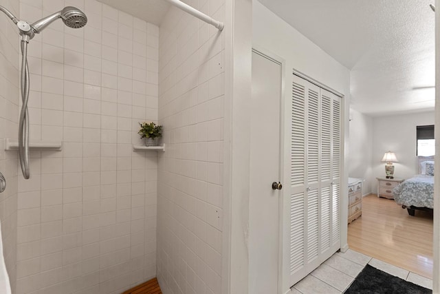 2730 Ohina St, Kihei, HI 96753 - ensuite bathroom featuring tiled shower, a textured ceiling, and wood finished floors