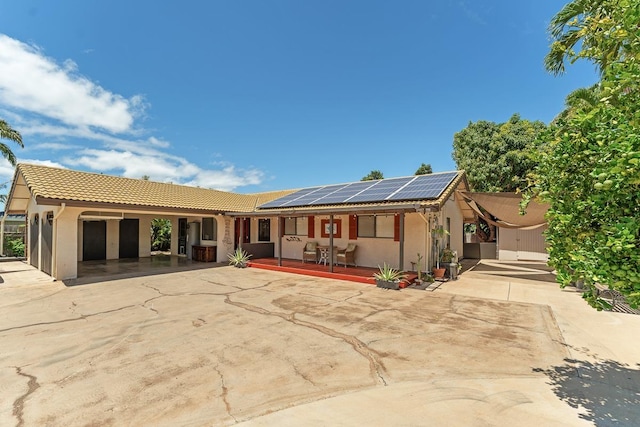 2730 Ohina St, Kihei, HI 96753 - view of front facade with solar panels, driveway, a tiled roof, stucco siding, and a porch