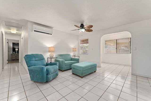 2730 Ohina St, Kihei, HI 96753 - living area featuring a wall mounted AC, light tile patterned floors, ceiling fan, arched walkways, and a textured ceiling