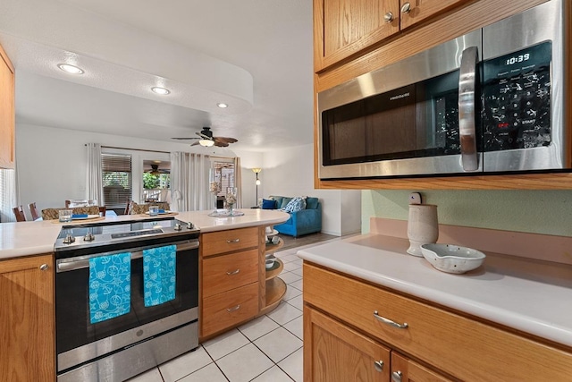 2730 Ohina St, Kihei, HI 96753 - kitchen with appliances with stainless steel finishes, light tile patterned flooring, light countertops, brown cabinetry, and a ceiling fan