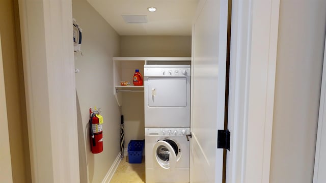 clothes washing area with stacked washer / dryer