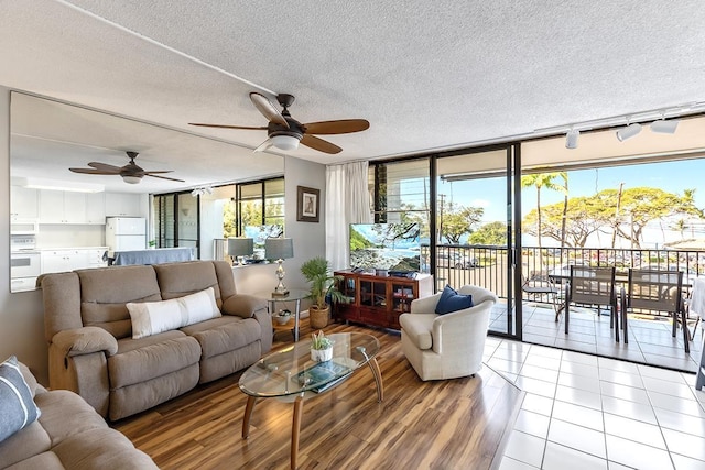 living room with expansive windows, a textured ceiling, and light tile patterned floors