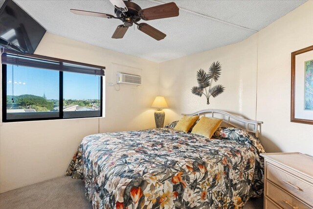 carpeted bedroom with a wall mounted air conditioner, ceiling fan, and a textured ceiling