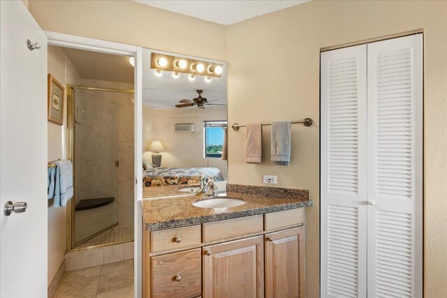 bathroom featuring ensuite bathroom, a stall shower, a ceiling fan, a closet, and vanity