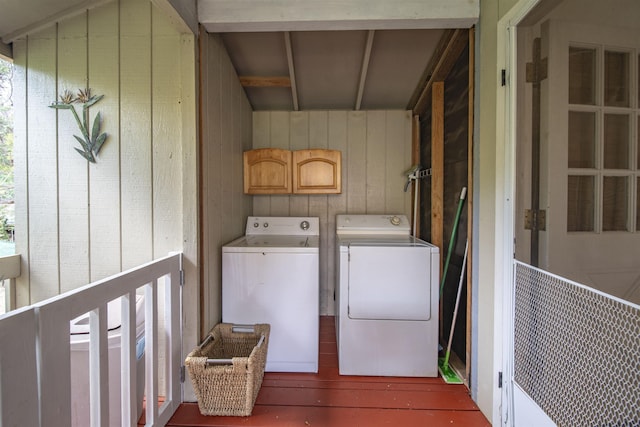 washroom featuring cabinets, dark hardwood / wood-style flooring, washer and dryer, and wood walls