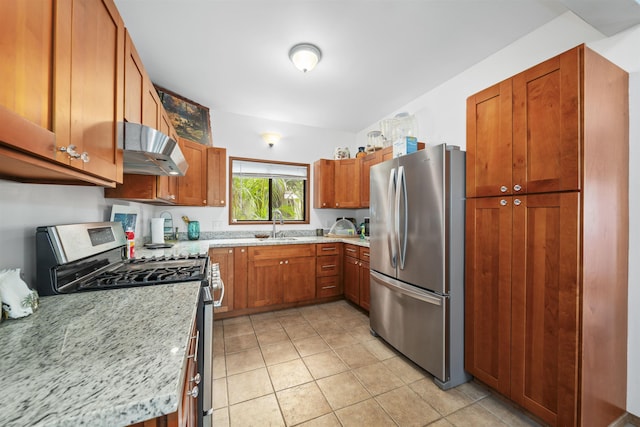 kitchen featuring appliances with stainless steel finishes, sink, light tile patterned floors, light stone countertops, and wall chimney exhaust hood