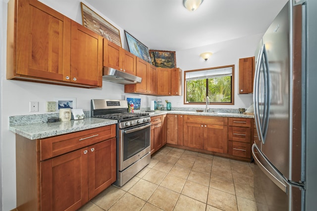 kitchen featuring light stone counters, sink, light tile patterned floors, and stainless steel appliances