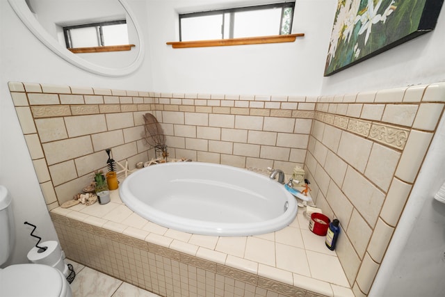 bathroom with a relaxing tiled tub and toilet