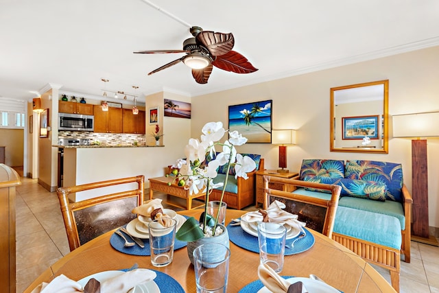 tiled dining space with crown molding and ceiling fan