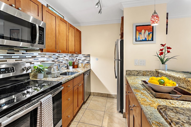 kitchen with sink, light stone counters, decorative light fixtures, light tile patterned flooring, and appliances with stainless steel finishes