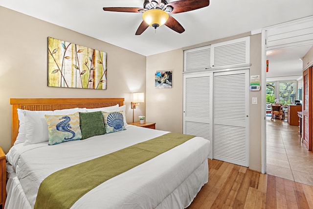 bedroom with ceiling fan, light wood-type flooring, and a closet