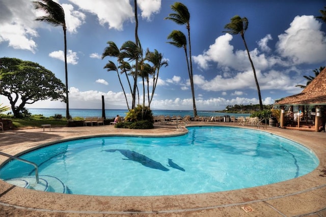 view of pool with a water view and a patio