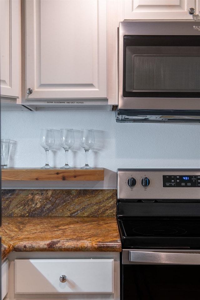 room details featuring white cabinetry and appliances with stainless steel finishes