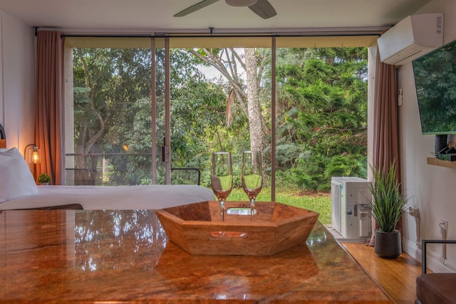 interior space with a wall mounted air conditioner and ceiling fan