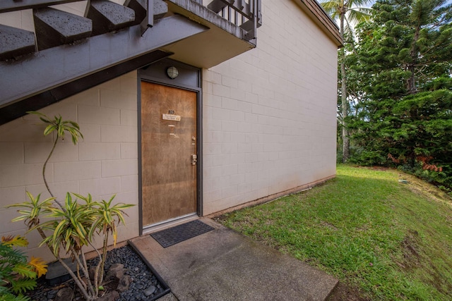 property entrance featuring a balcony and a yard