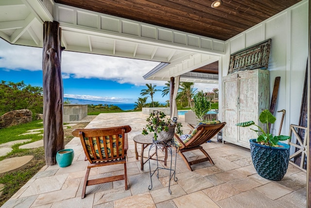 view of patio featuring a water and mountain view