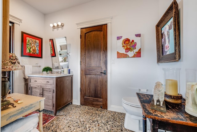 bathroom with toilet, tile floors, and vanity