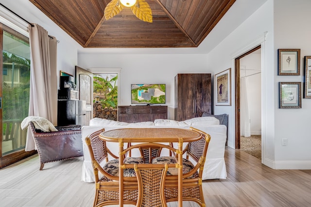 dining room featuring light wood-type flooring, ceiling fan, and wood ceiling