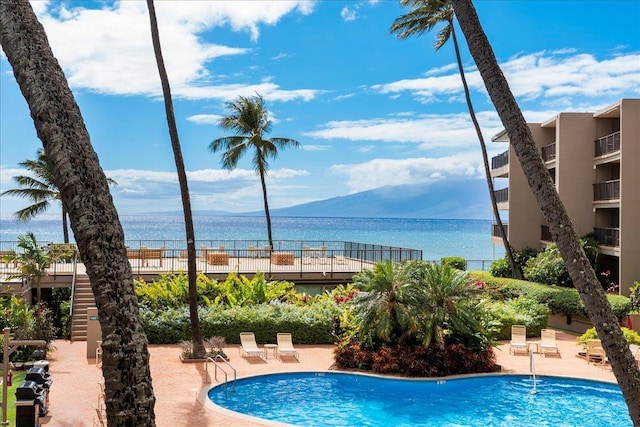 view of swimming pool with a patio area and a water and mountain view