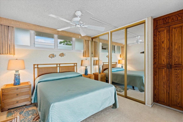 bedroom with multiple closets, ceiling fan, and a textured ceiling