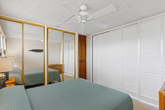 bedroom featuring multiple closets, carpet, and ceiling fan