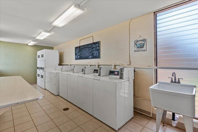 washroom with stacked washer / dryer, washer and clothes dryer, sink, and light tile patterned floors