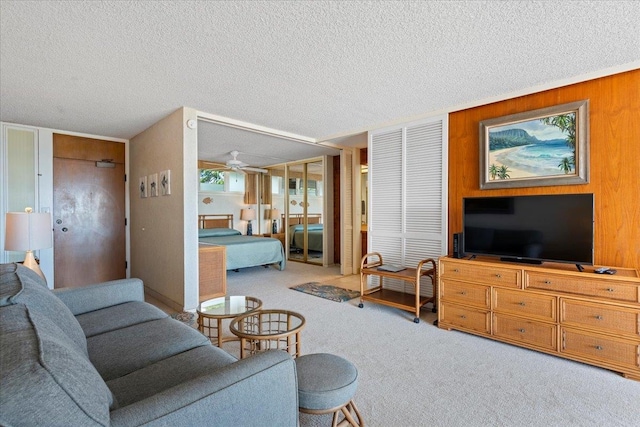 carpeted living room featuring a textured ceiling and wooden walls