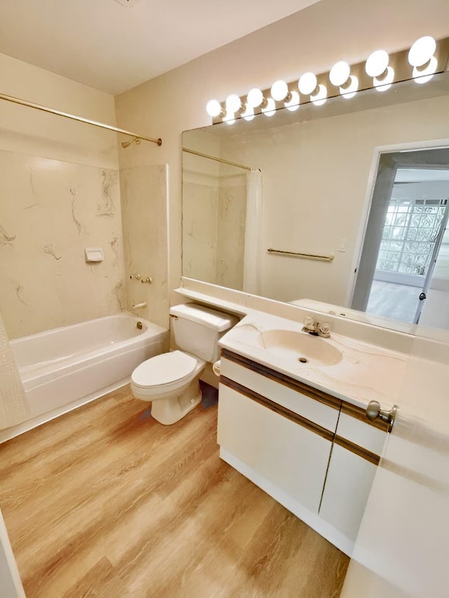 full bathroom featuring vanity, toilet, wood-type flooring, and shower / tub combo