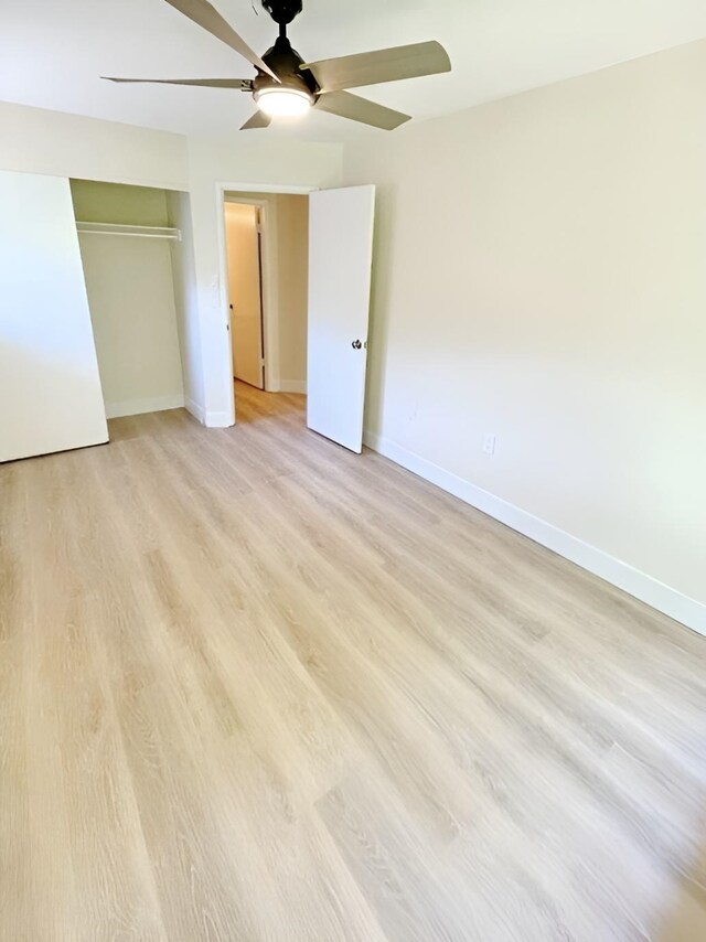 unfurnished bedroom with light hardwood / wood-style floors, a closet, and ceiling fan