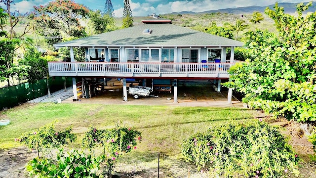 back of house featuring a yard and a deck with mountain view